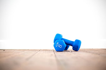 Blue Dumbbells on Wooden Floor with White Background