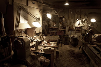 Dimly lit rustic carpentry workshop with tools and wood shavings