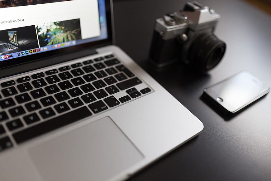 MacBook, Vintage Camera, and Smartphone on Desk