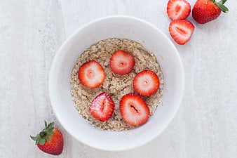 Overhead view of oatmeal bowl with fresh strawberries