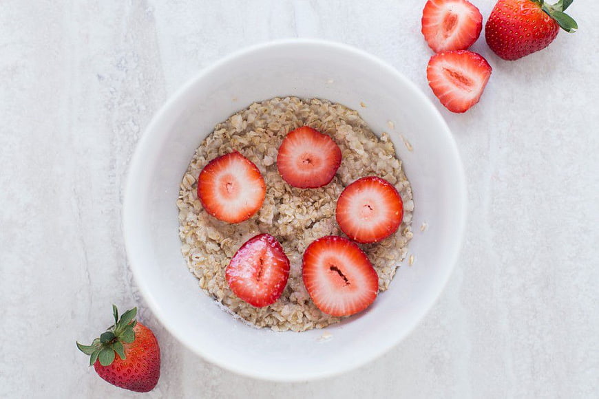 Overhead view of oatmeal bowl with fresh strawberries