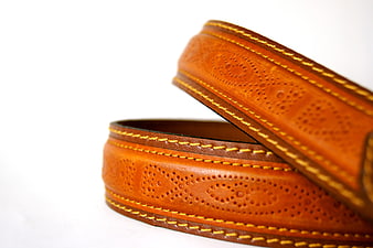 Close-up of brown leather belt with yellow stitching