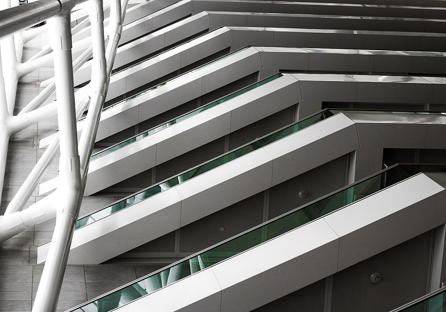 Modern white architectural escalators with diagonal lines