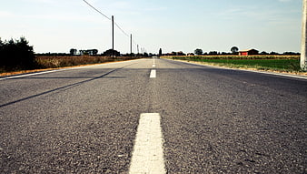 Low angle view of empty asphalt road with white lines