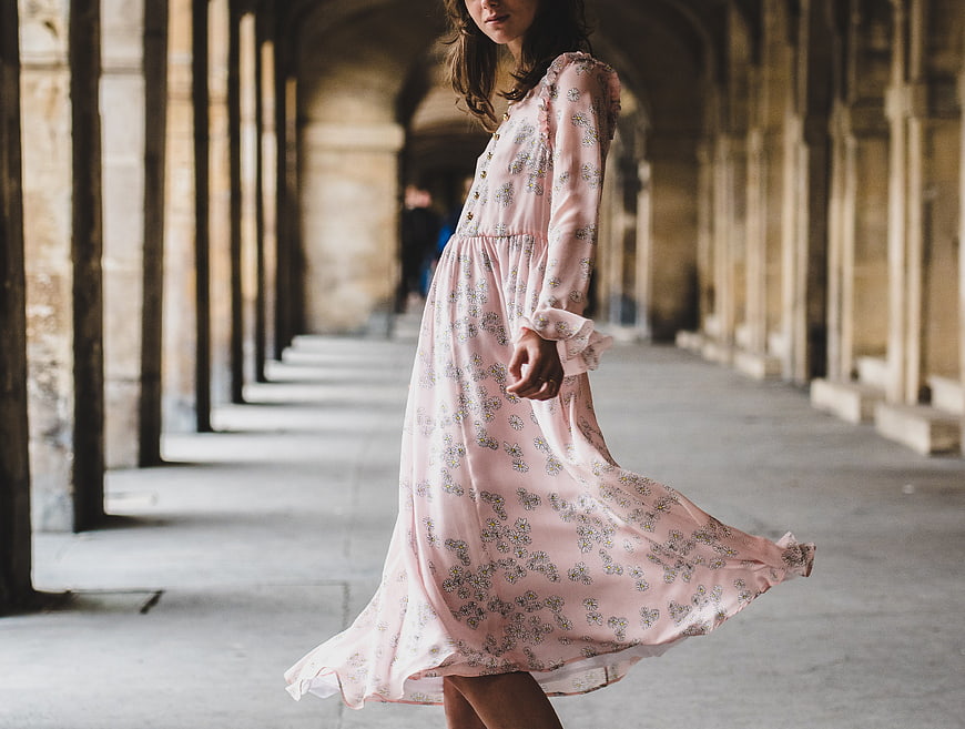 Woman in Pink Floral Dress Walking in Stone Arcade