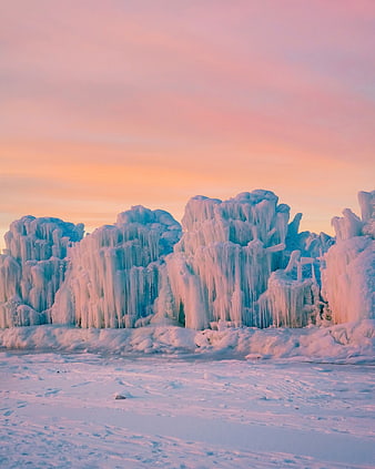 Frozen Ice Formations on Snowy Shore at Sunset