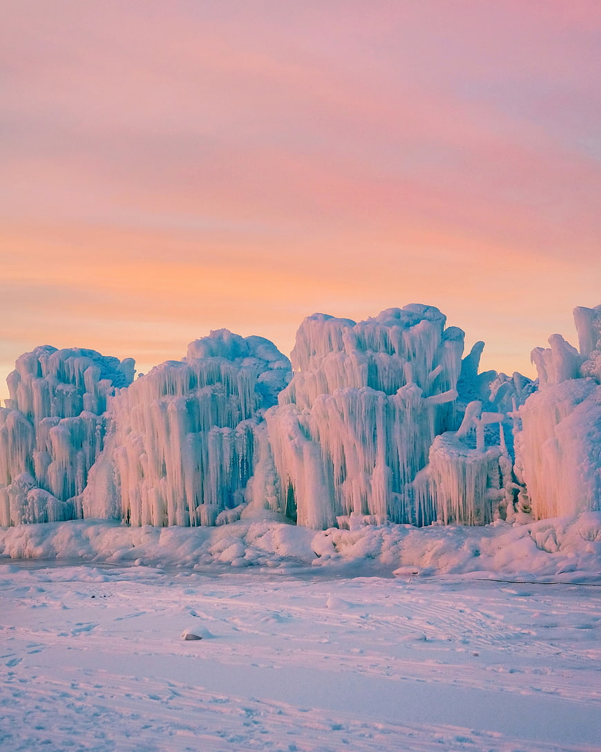 Frozen Ice Formations on Snowy Shore at Sunset