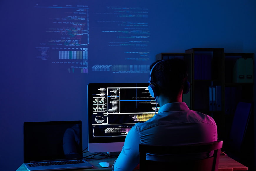 Programmer Working Late Night in Dark Office with Blue Screen Light