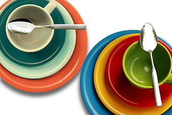 Colorful Stacked Plates and Cups with Spoons on White
