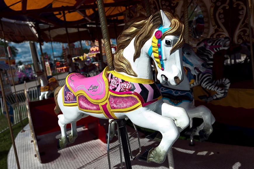 White Carousel Horse with Pink Saddle at Amusement Park