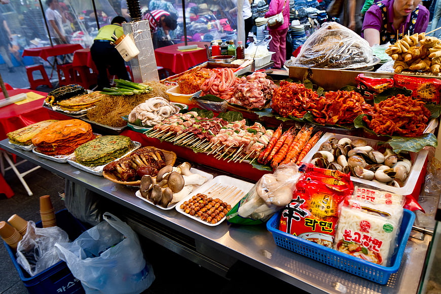 Vibrant Korean street food market stall with skewers and ingredients
