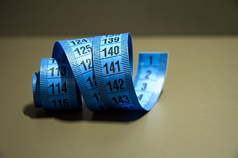 Blue measuring tape on beige background for fitness and diet