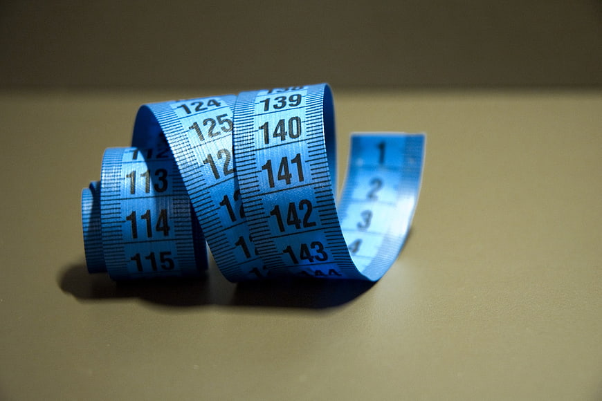 Blue measuring tape on beige background for fitness and diet