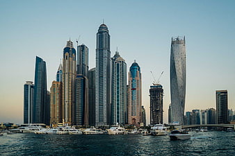 Dubai Marina skyline with skyscrapers and yachts at sunset