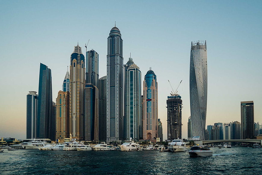Dubai Marina skyline with skyscrapers and yachts at sunset