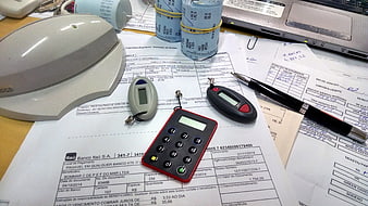Office desk with security tokens, receipts, and laptop