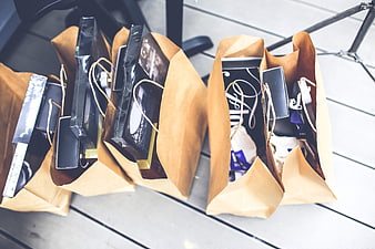 Brown paper shopping bags filled with gifts on wooden deck