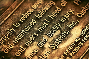 Close-up of engraved warning text on rusty metal plate