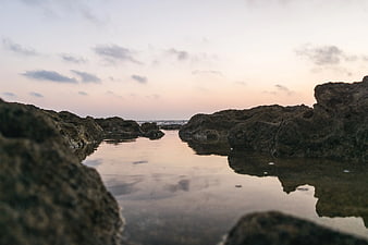 Serene Tide Pool Reflections Between Rocky Coastline at Dusk