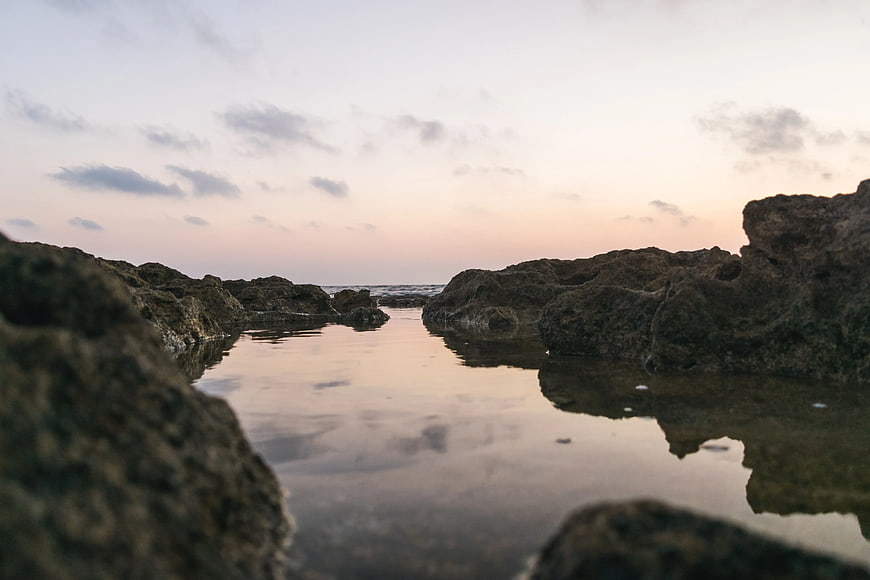 Serene Tide Pool Reflections Between Rocky Coastline at Dusk