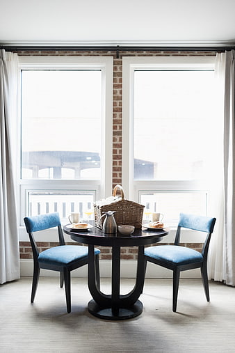 Cozy breakfast setting with blue chairs and picnic basket