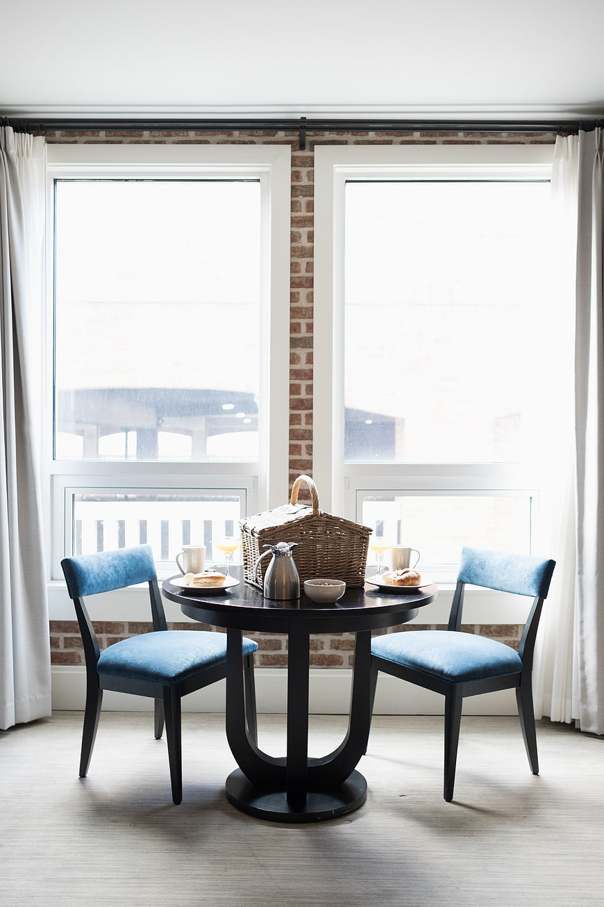 Cozy breakfast setting with blue chairs and picnic basket
