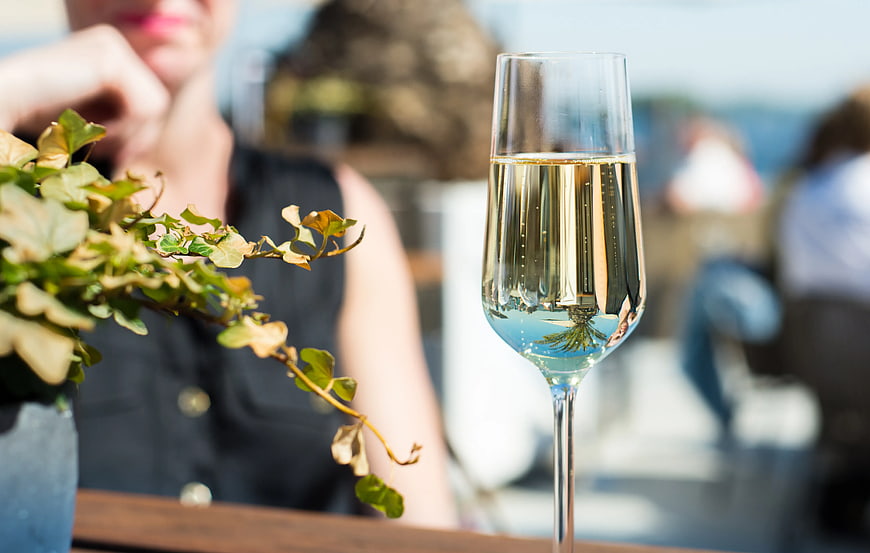 Glass of white wine on outdoor table with blurred background