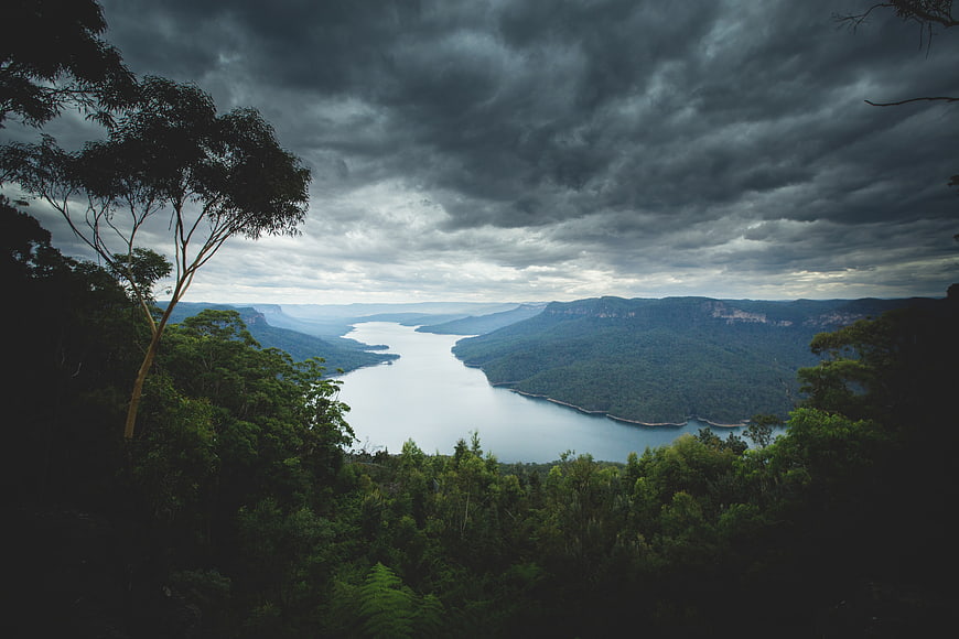 Dramatic moody landscape of a river valley under storm clouds