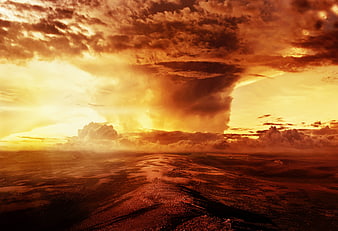 Dramatic fiery sunset over a wet, textured landscape with towering storm clouds