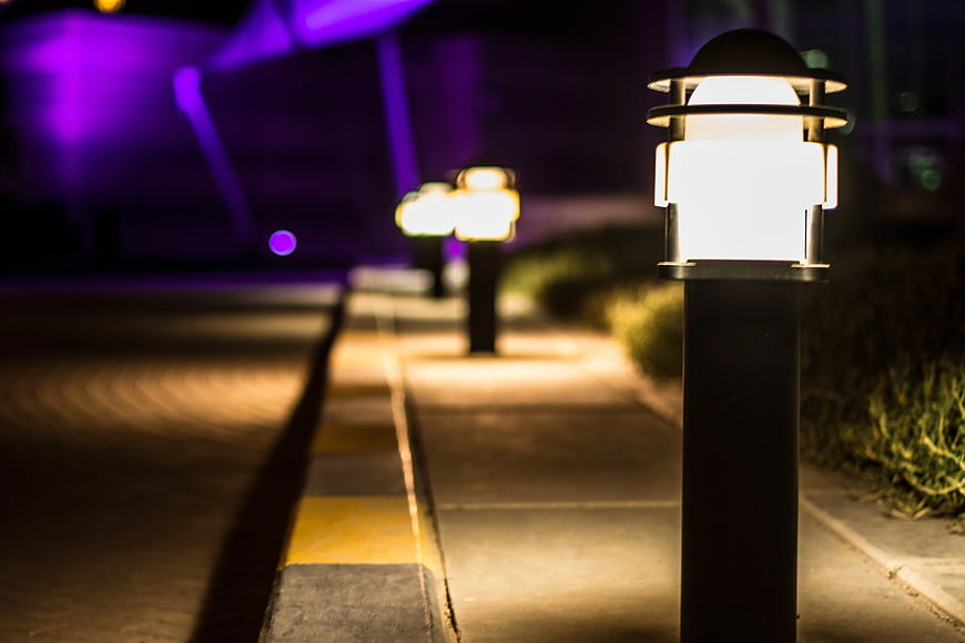 Modern bollard lights illuminating a pathway at night