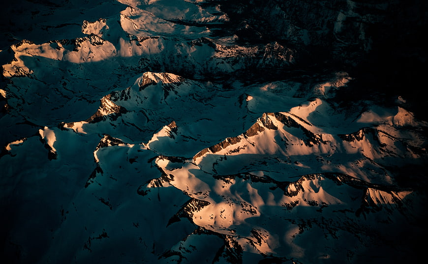Aerial View of Snow-Capped Mountains at Golden Hour