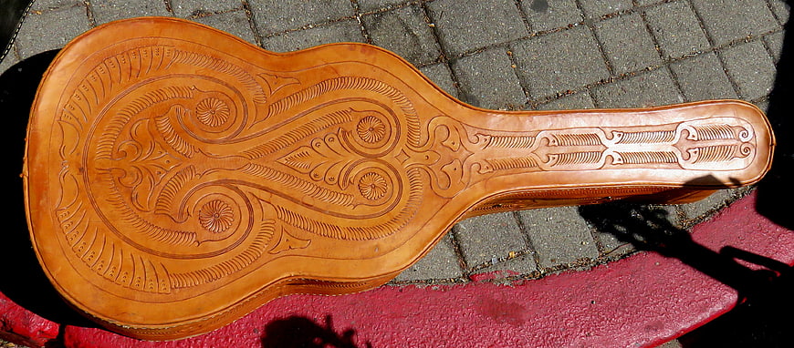 Vintage tooled leather guitar case on pavement