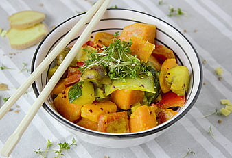 Bowl of roasted vegetables with chopsticks and microgreens