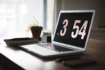 Laptop Displaying 3:54 PM on Wooden Desk