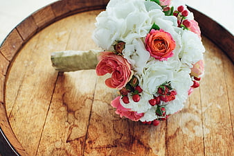 White and Pink Wedding Bouquet on Wooden Barrel Top