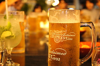 Chilled Beer Mug With Condensation In A Lively Bar Setting