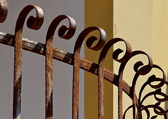 Close-up of rusty wrought iron gate with scrollwork
