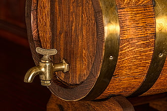 Close-up of wooden beer barrel with brass tap and hoops