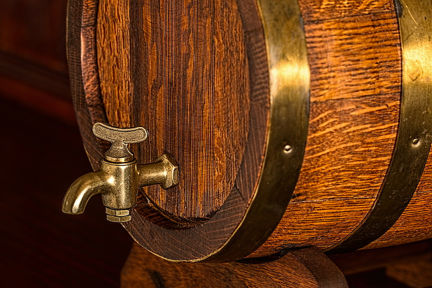 Close-up of wooden beer barrel with brass tap and hoops