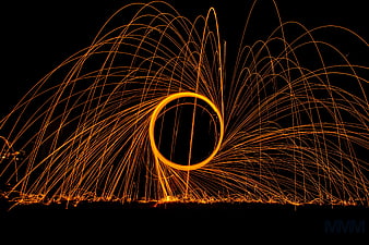 Abstract steel wool sparks forming a glowing circle at night