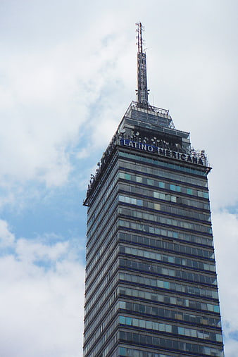 Low angle view of Torre Latinoamericana skyscraper against cloudy sky