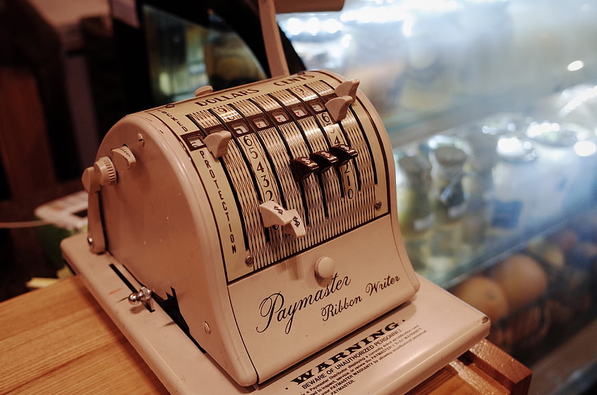 Vintage Paymaster Ribbon Writer Cash Register on Wooden Counter