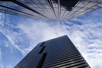 Low angle view of modern glass skyscrapers against blue sky