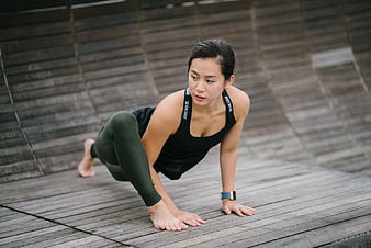 Woman performing yoga pose on wooden deck