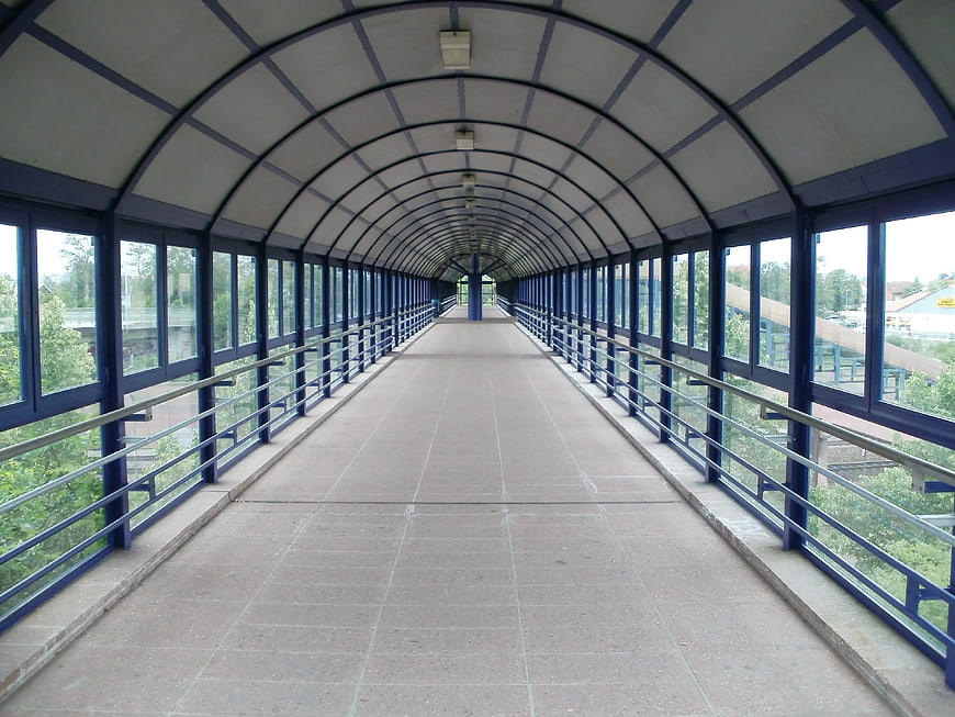 Empty blue arched pedestrian bridge with glass windows