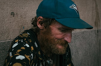 Portrait of bearded man in blue cap looking down
