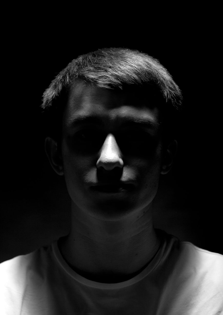 Dramatic Black and White Portrait of Young Man in Shadow