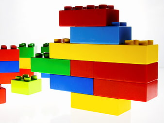 Colorful plastic building blocks stacked on white background