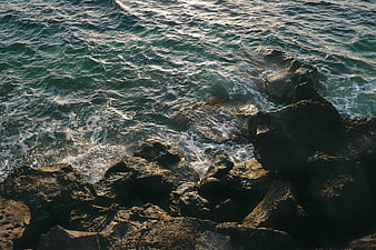 High Angle View of Ocean Waves Crashing on Rocky Shore