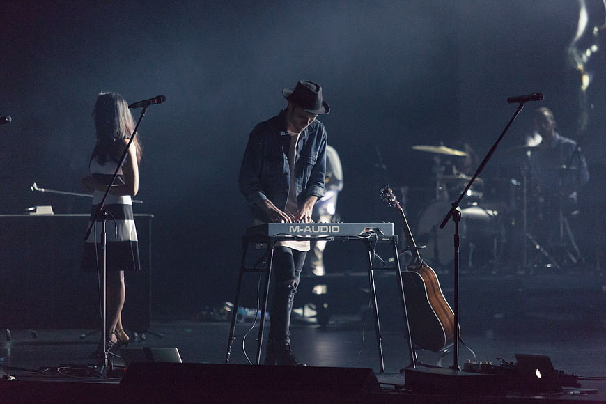 Band performing live on stage with keyboardist and singer